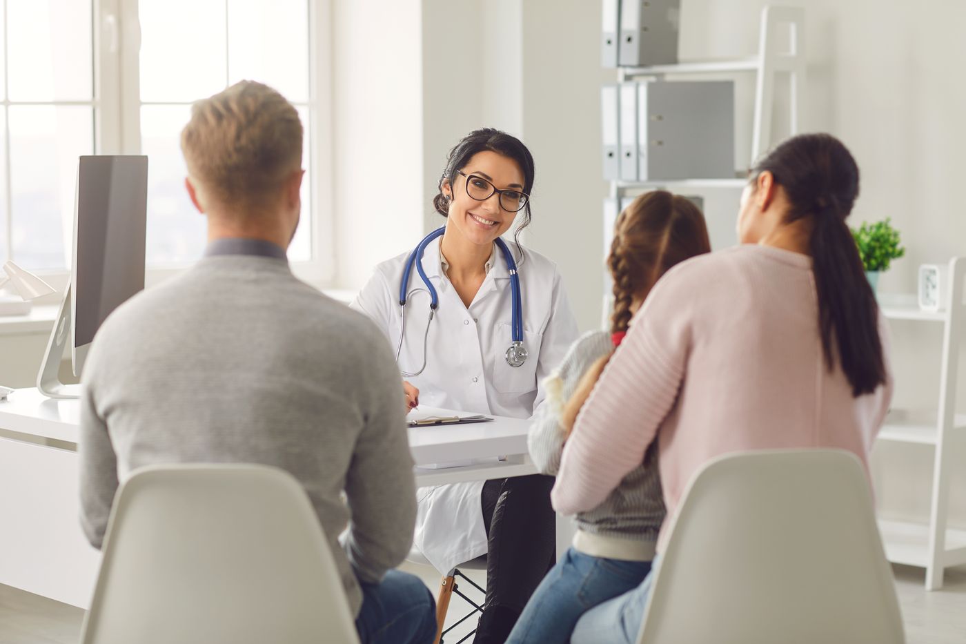 Dentist consulting with family in modern dental office