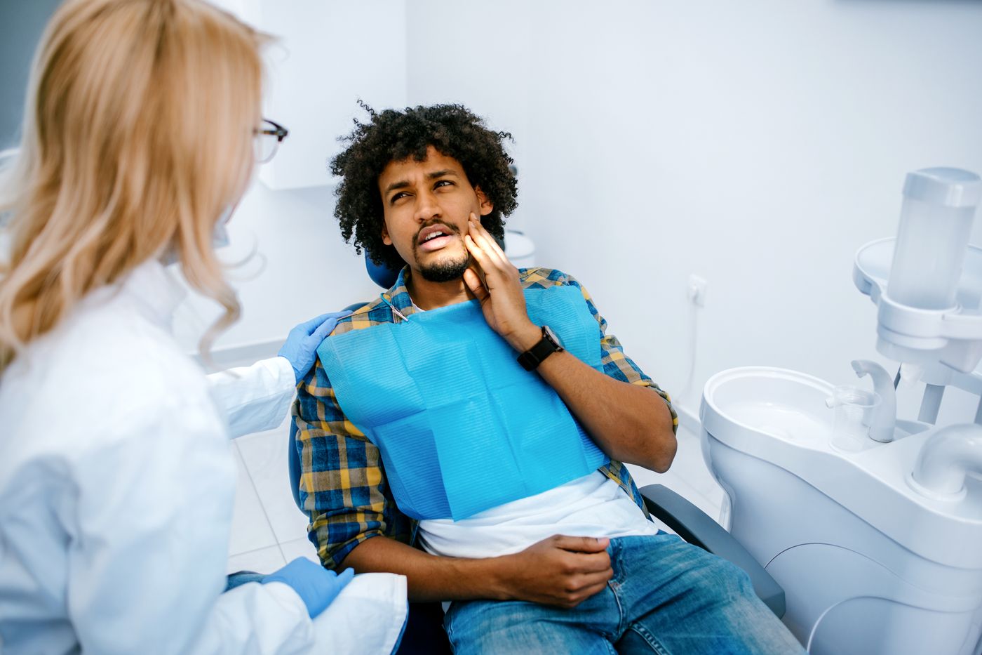 Dental hygienist examining patient's jaw in dental office